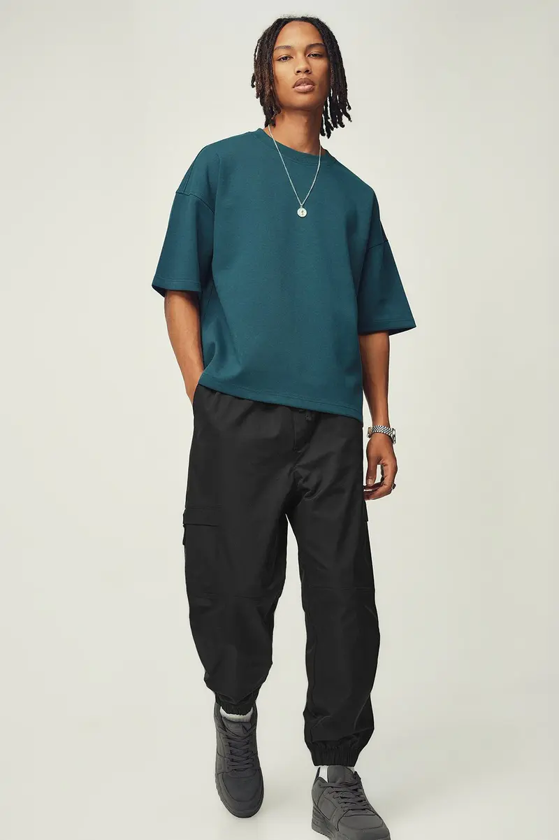 Calças jogger em poliéster · Homem · Preto · Modelo 2